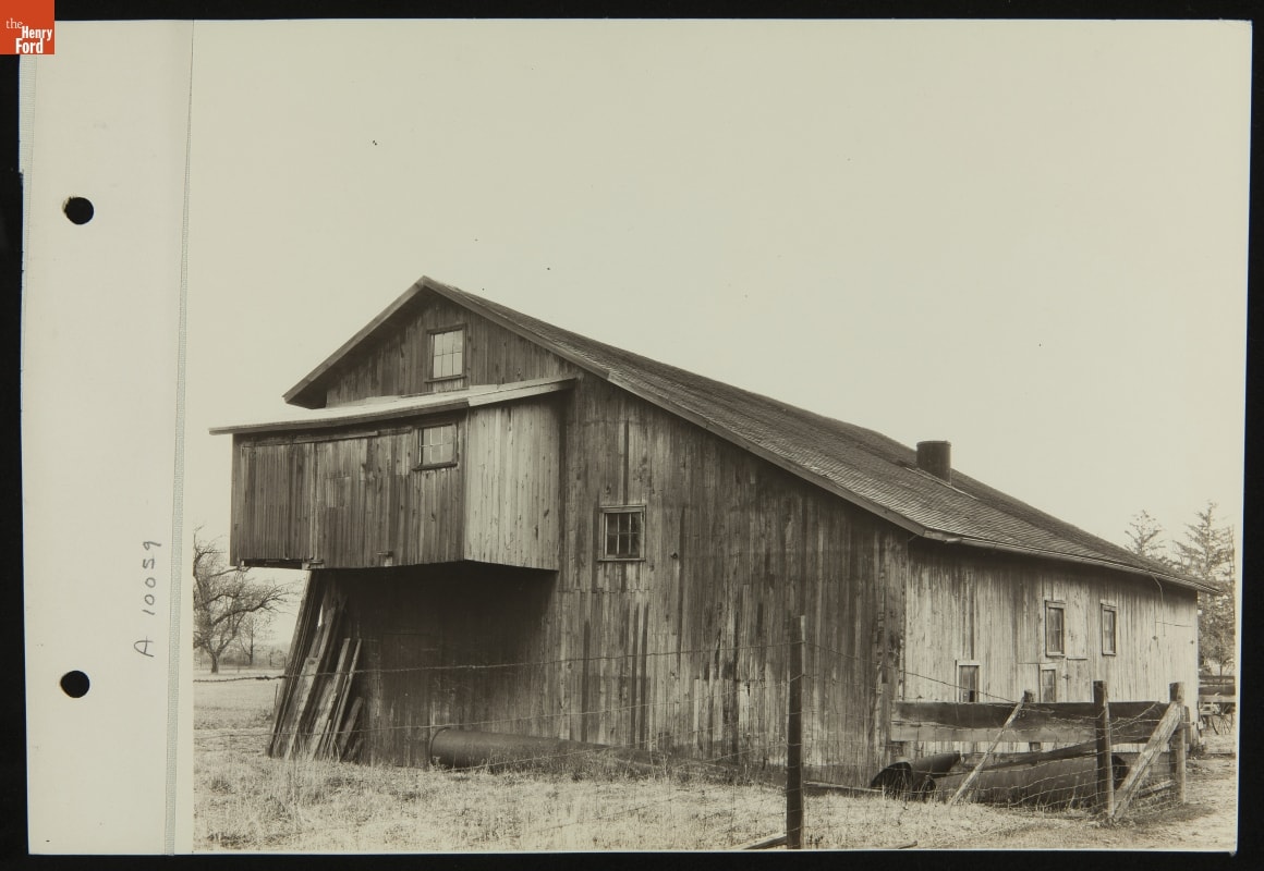 Black-and-white photo of a wooden building with a sloped roof