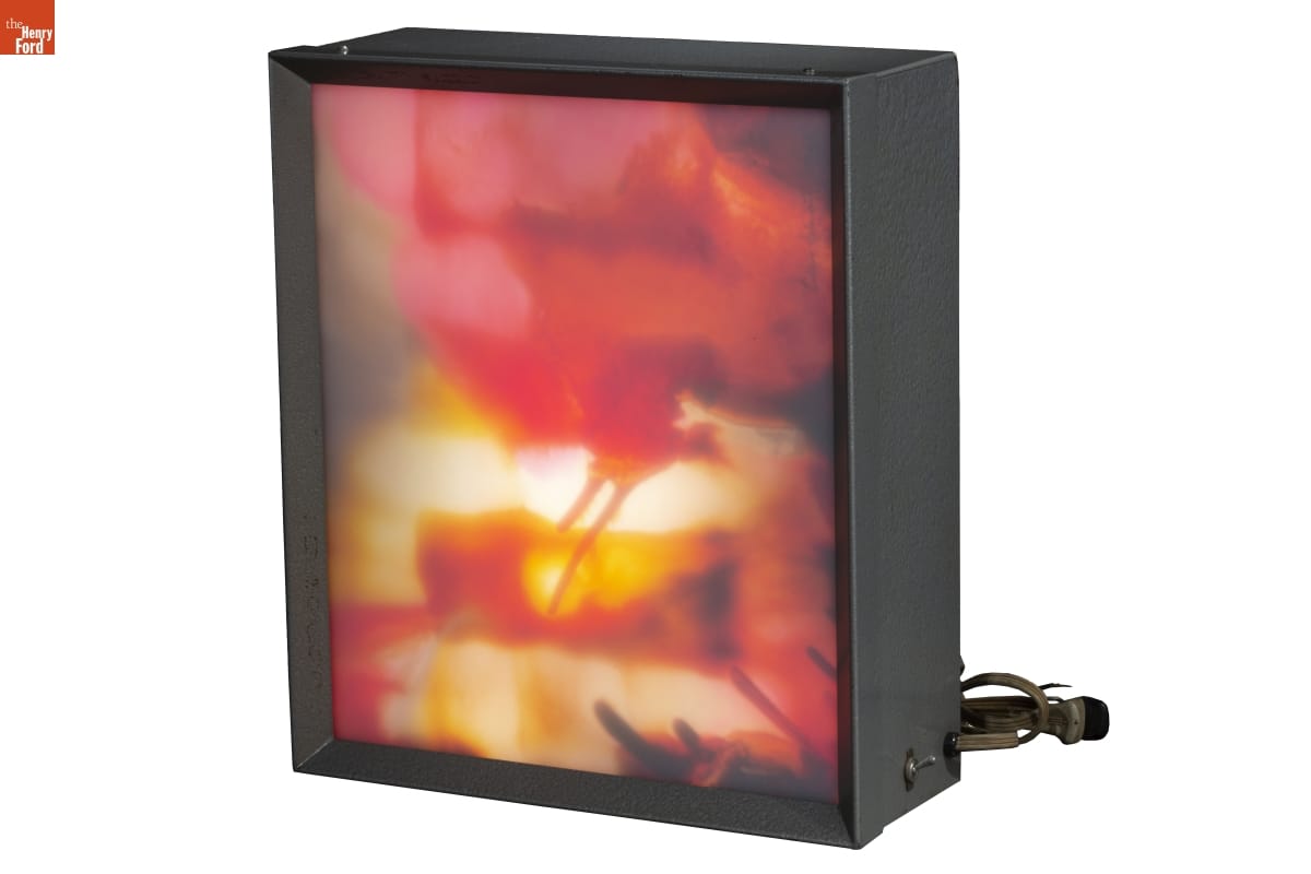 Black box with plug, displaying image of abstract, organic colors, backlit