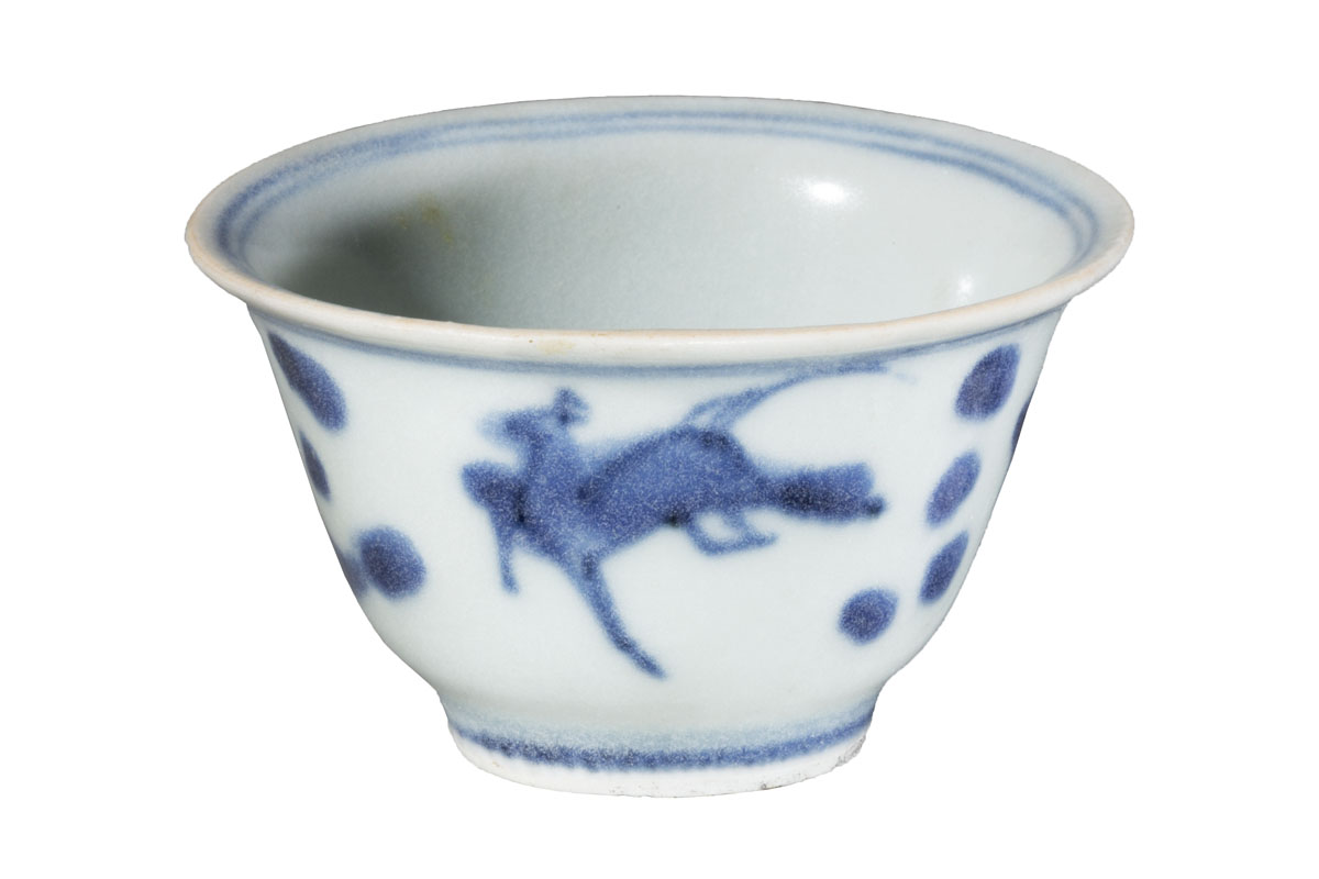 Simple white handless teacup with blue decorations