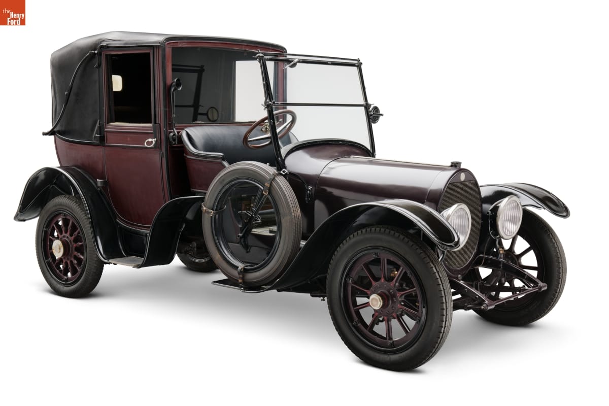 Boxy maroon and black car with open driver's seat