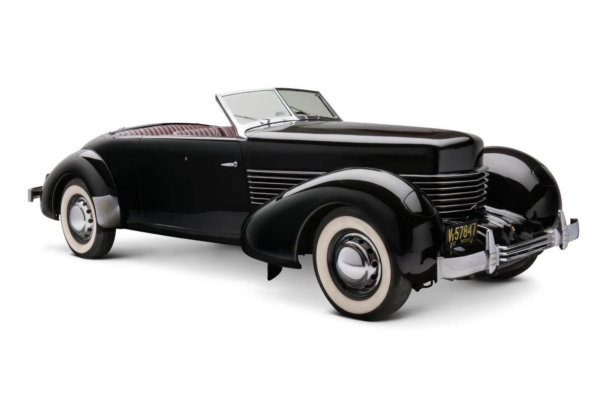 Long black convertible with swooping lines and whitewall tires