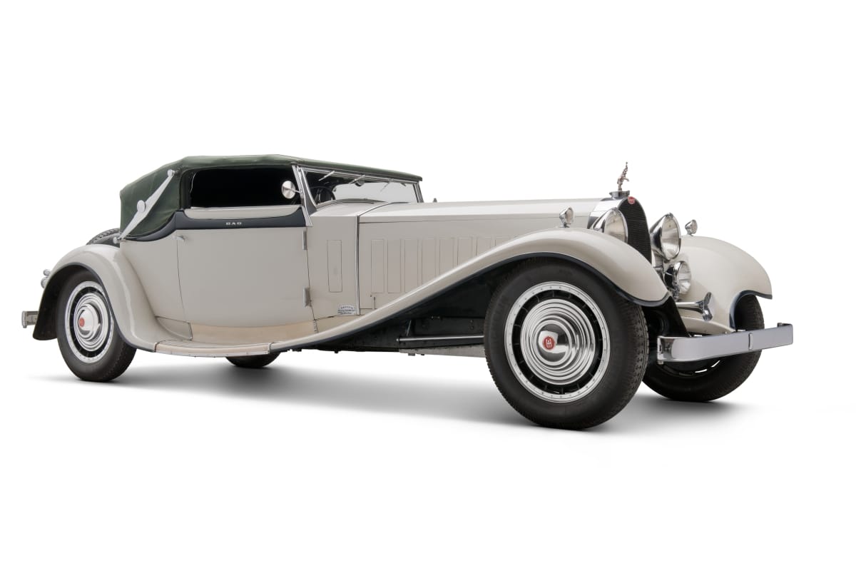 Long white car with scrolling style lines and green fabric top