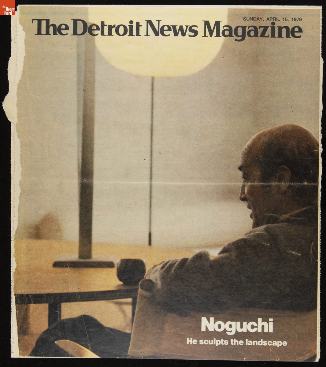 Page with text and image from behind/side of man sitting in a chair at a table with a globe-shaped lamp behind it
