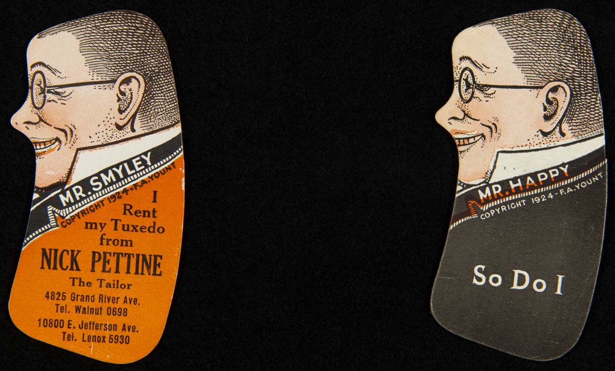 Two cards, each at far side of image, shaped like torso and face of a man, one wearing an orange coat and one a black coat; contains text