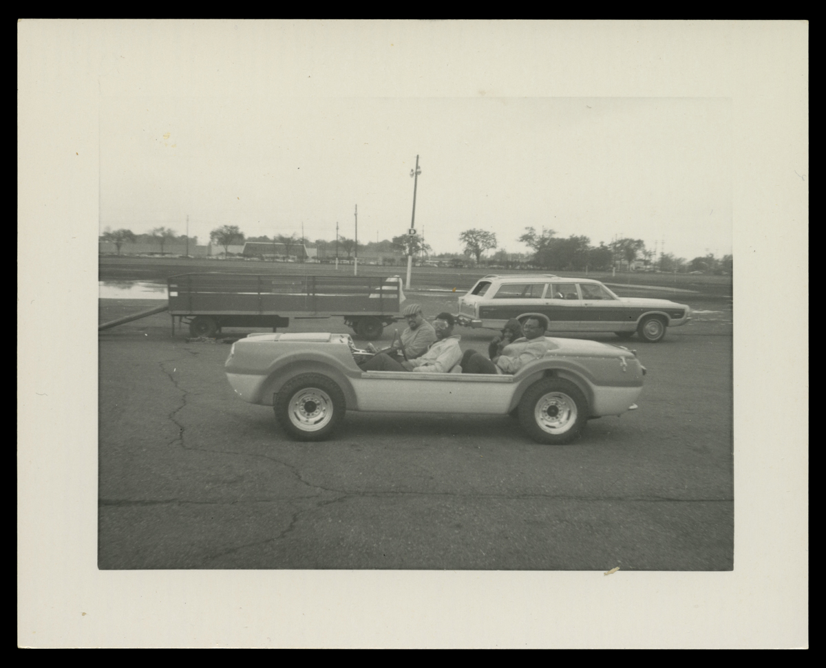 Three men in doorless, open top vehicle