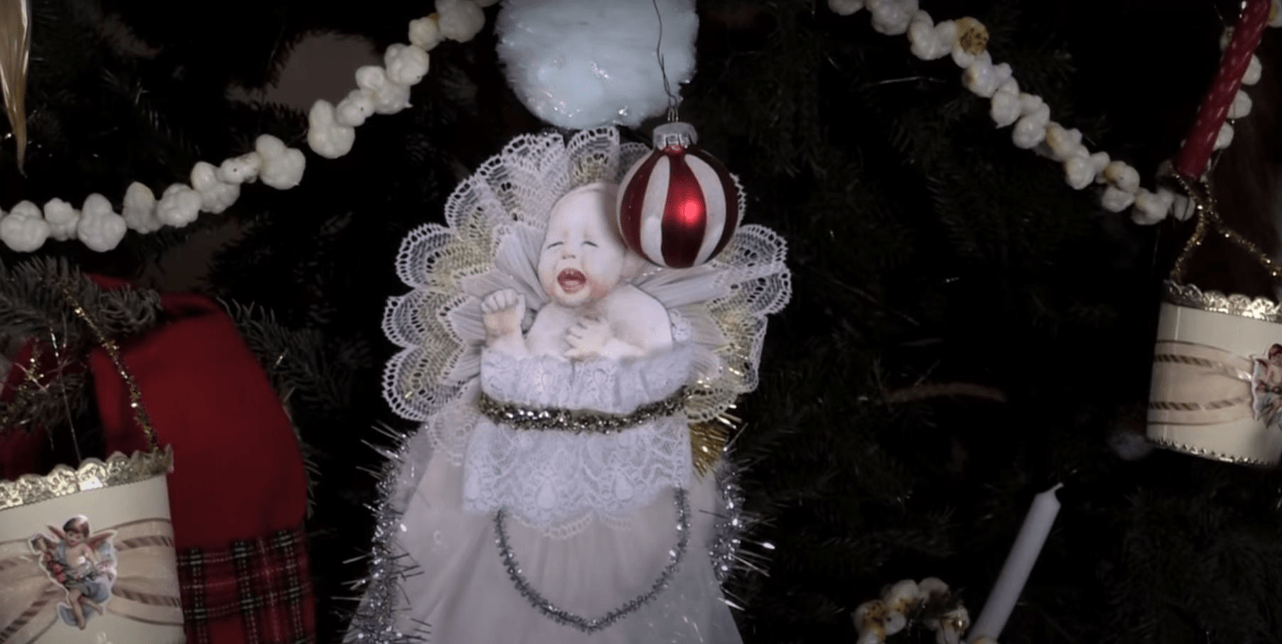 The screaming baby scrap-art on the Wright Home Christmas tree, both in the original photo and during Holiday Nights in Greenfield Village GIF cycling through two images, one black-and-white and one in color, each showing part of a Christmas tree with a large ornament of a screaming baby