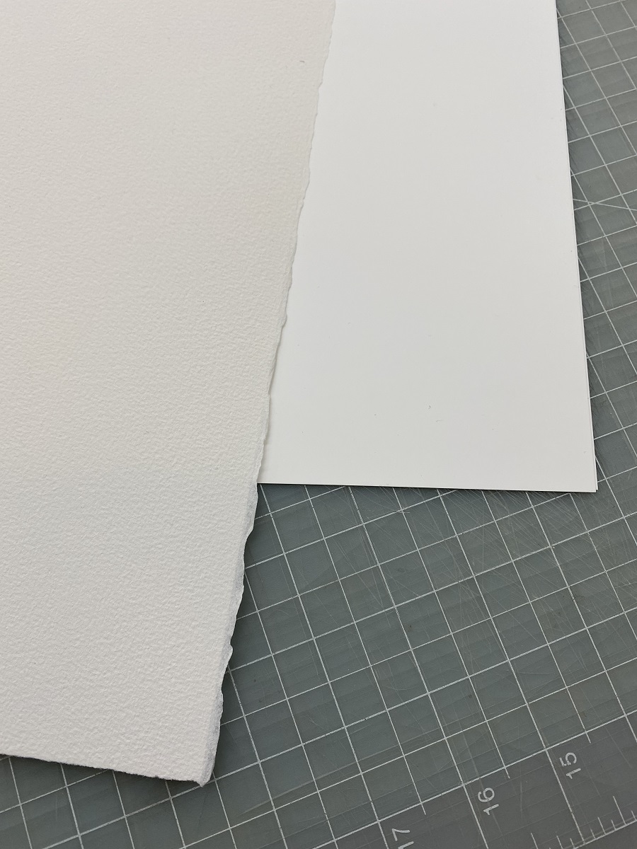 Two types of white paper lying overlapped on a grid background