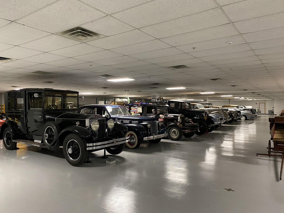 Cars in our new Main Storage Building A row of a variety of cars parked in a large room