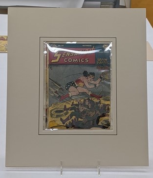 Comic book in mat for framing Plastic-covered "Sensation Comics" comic book in mat