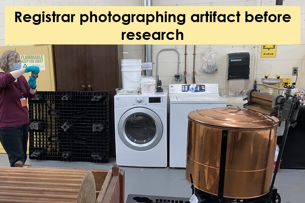 Registrar photographing an artifact before conservation treatment Woman in surgical mask and blue gloves photographing what appears to be a copper tub in front of a washer and dryer