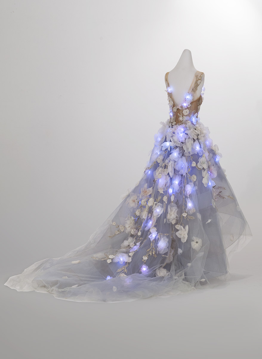 Back view of dress on dress form with glowing blue lights integrated into bodice and skirt
