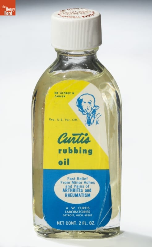 Bottle with clear liquid and yellow and blue label with text and image of man's profile