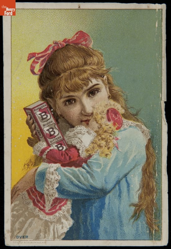 Little girl with red ribbon in her blonde hair, wearing blue dress, holds box and doll