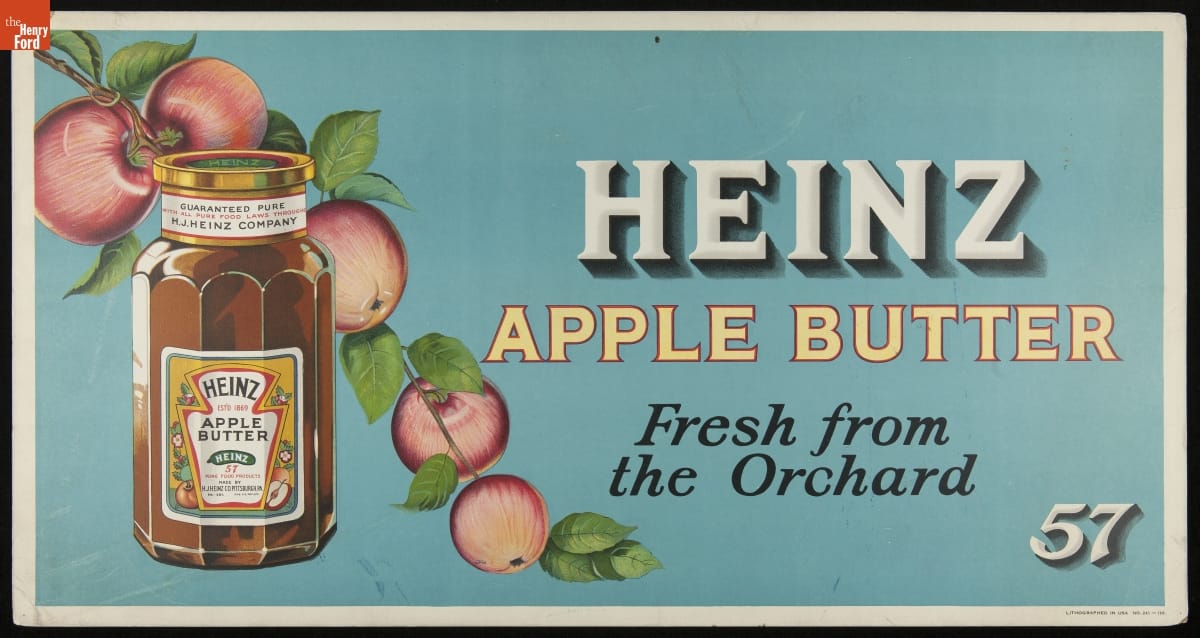 Blue sign with text and image of apple bough and jar of apple butter
