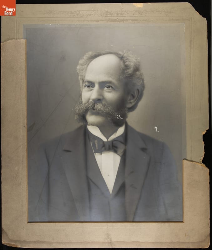 Portrait of seated man in suit with mustache and muttonchops