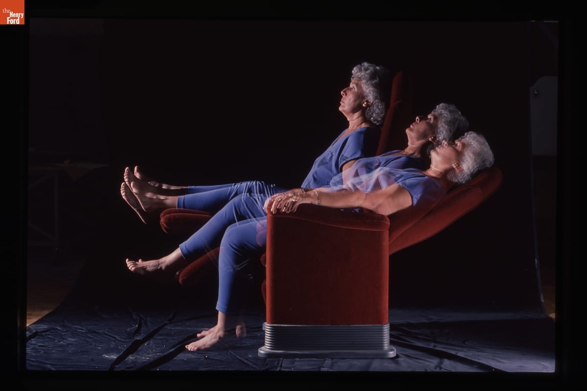 Photo with three superimposed images of a woman with gray hair wearing blue scrubs leaning back in a burnt-orange reclining chair