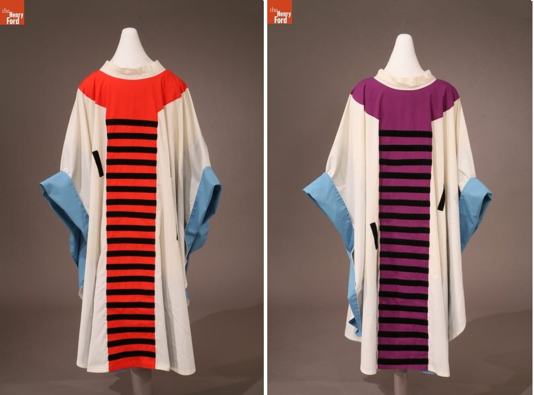 Two white robes with blue bands around the wrists, one with a red center panel with black stripes; the other with an purple center panel with black stripes