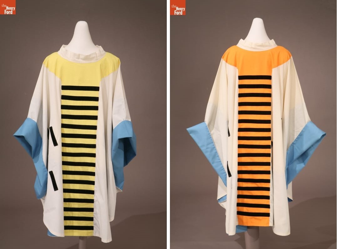 Two white robes with blue bands around the wrists, one with a yellow center panel with black stripes; the other with an orange center panel with black stripes