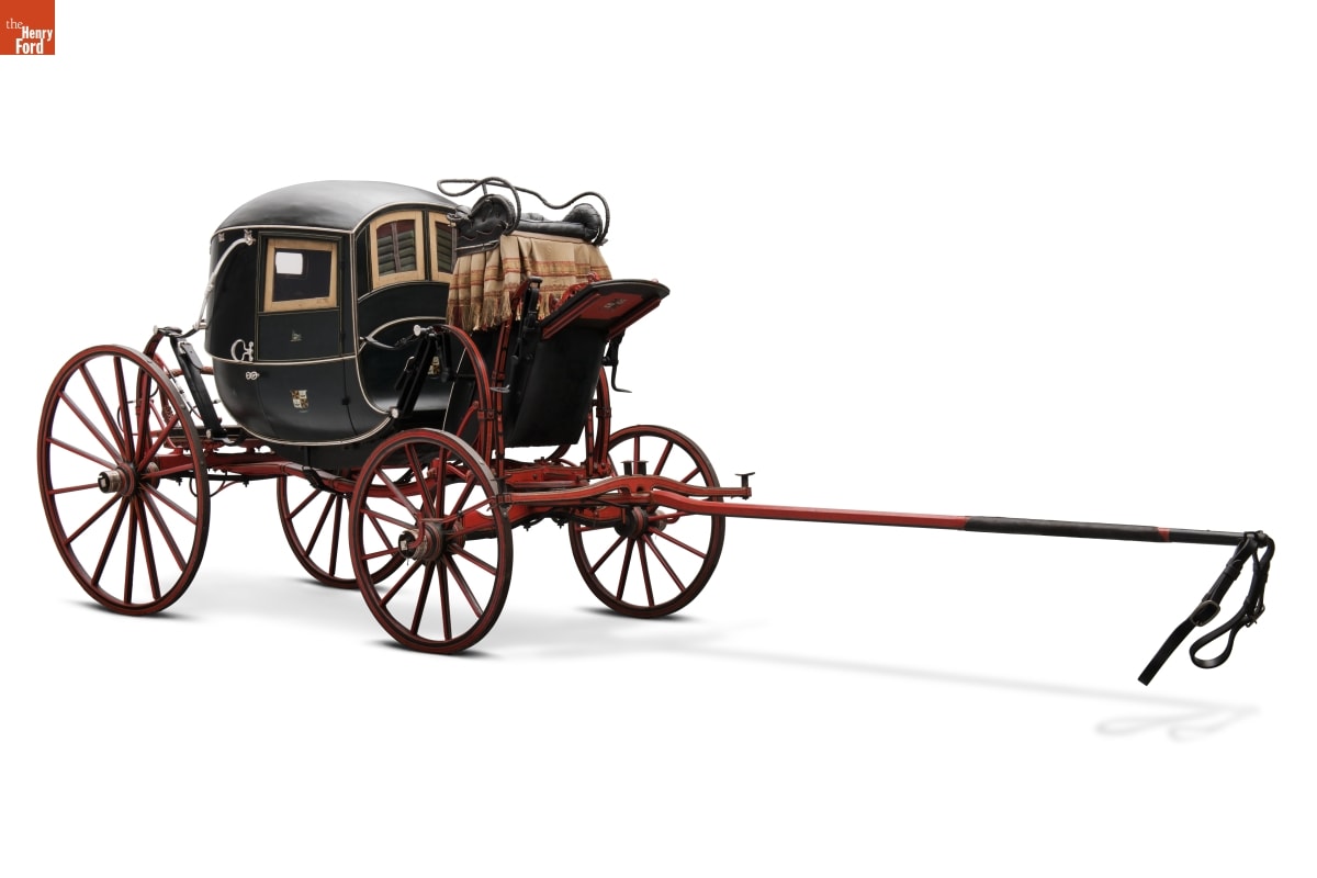 Rounded black enclosed carriage with red wheels