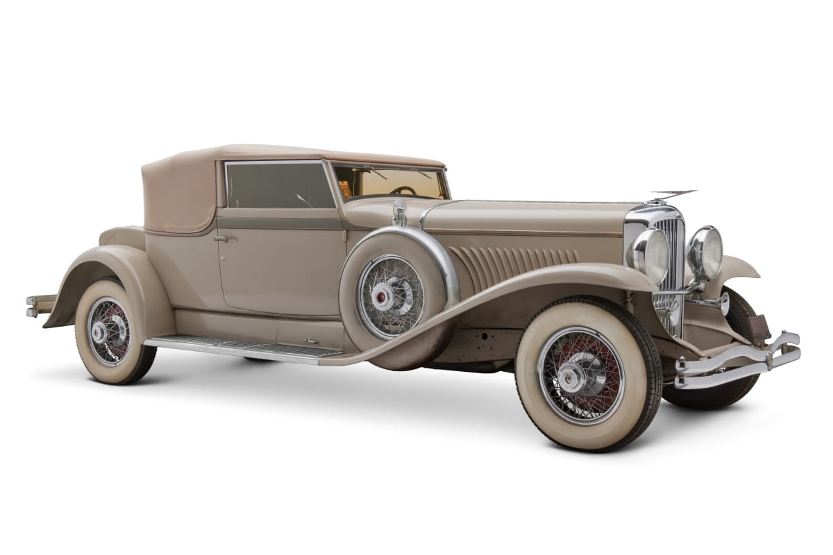 Long beige car with swooping fenders and color-matching tires